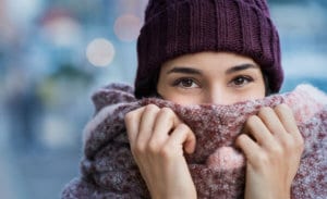 a woman in winter clothes hiding her face slightly